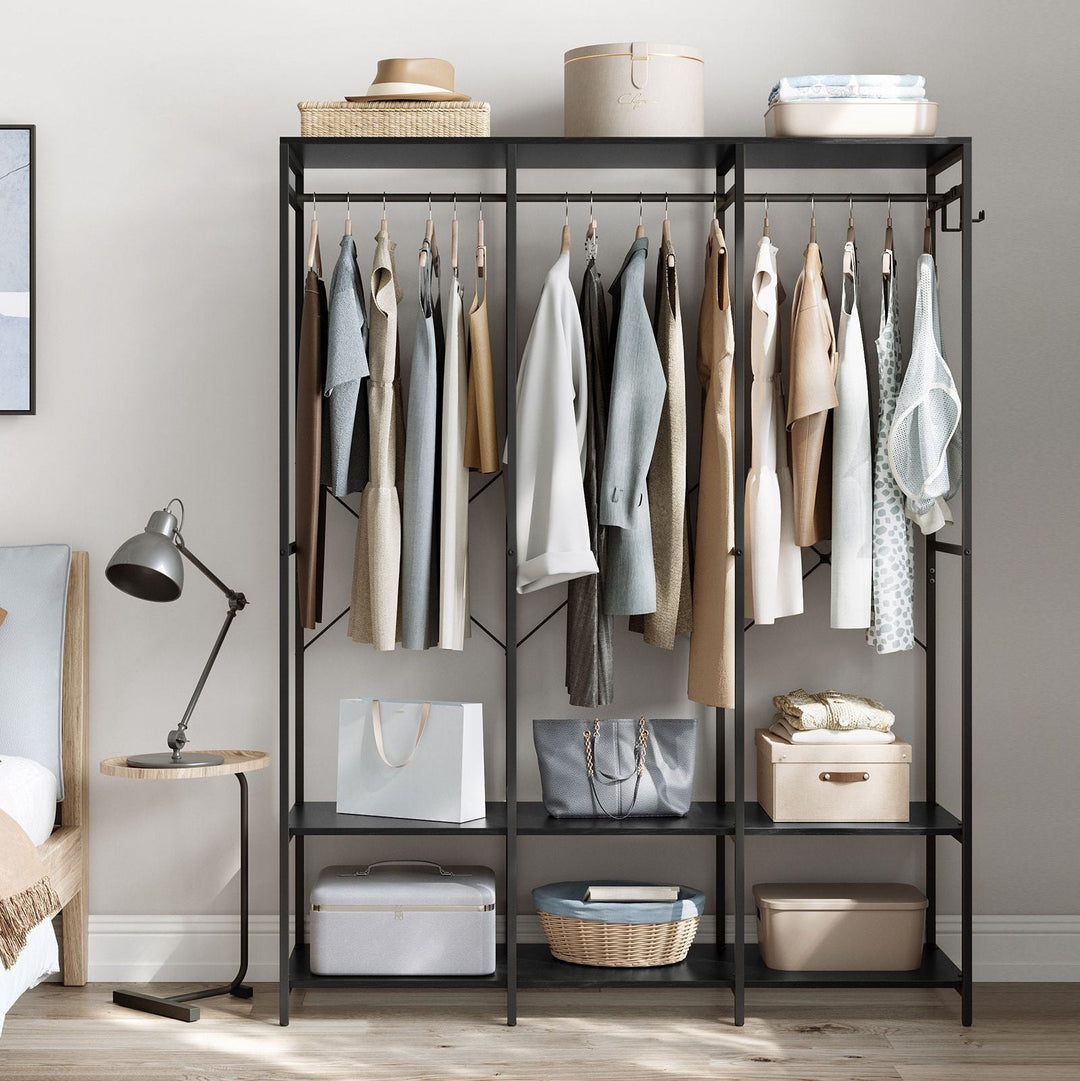 Åbent garderobeskab i sort metal og hvid stof med hængende tøj og hatte i et lille skandinavisk soveværelse med seng og læselampe