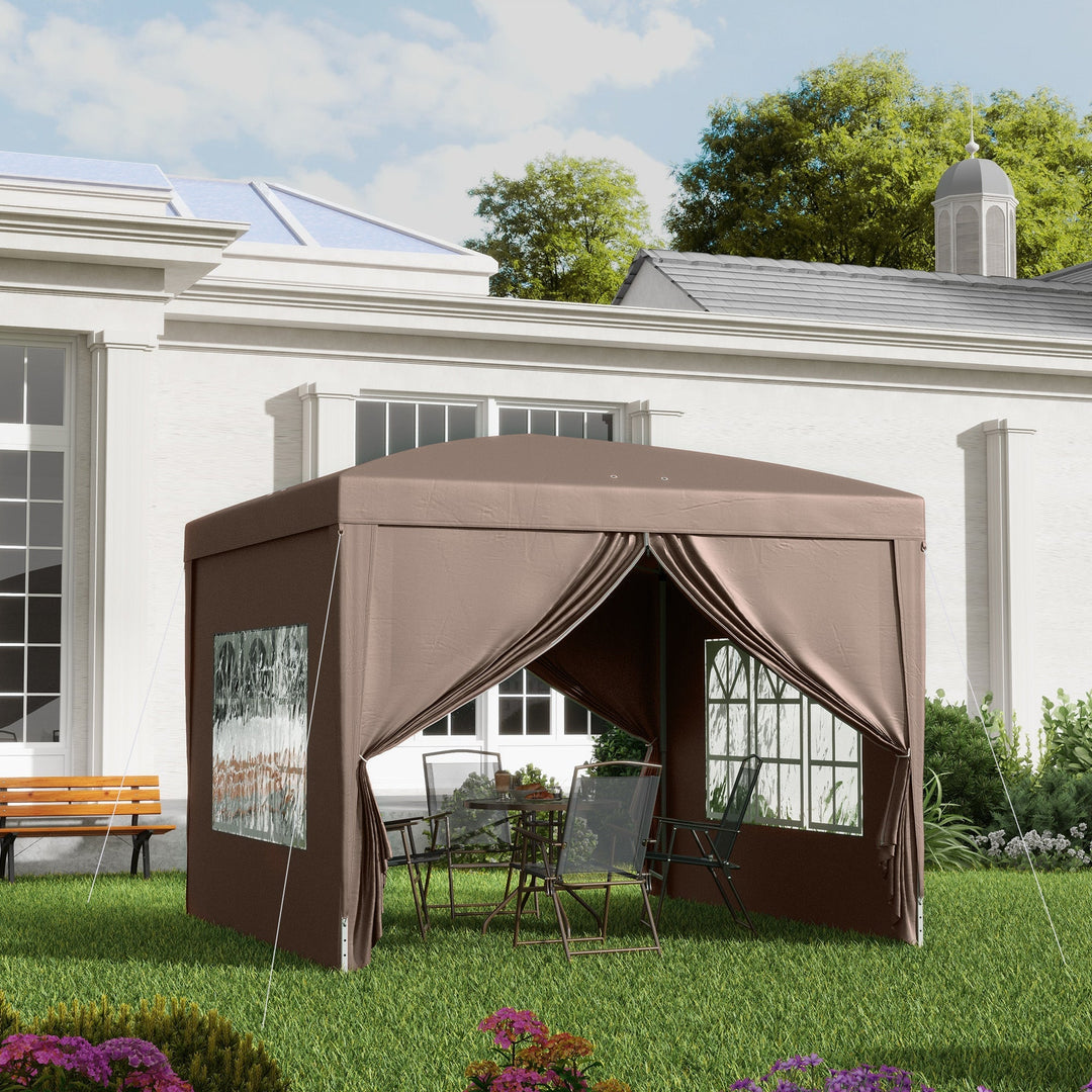 Brun pavillon med faste sidevægge opstillet på græsplæne foran hvidt hus med havestole indeni klar til sommerbrug