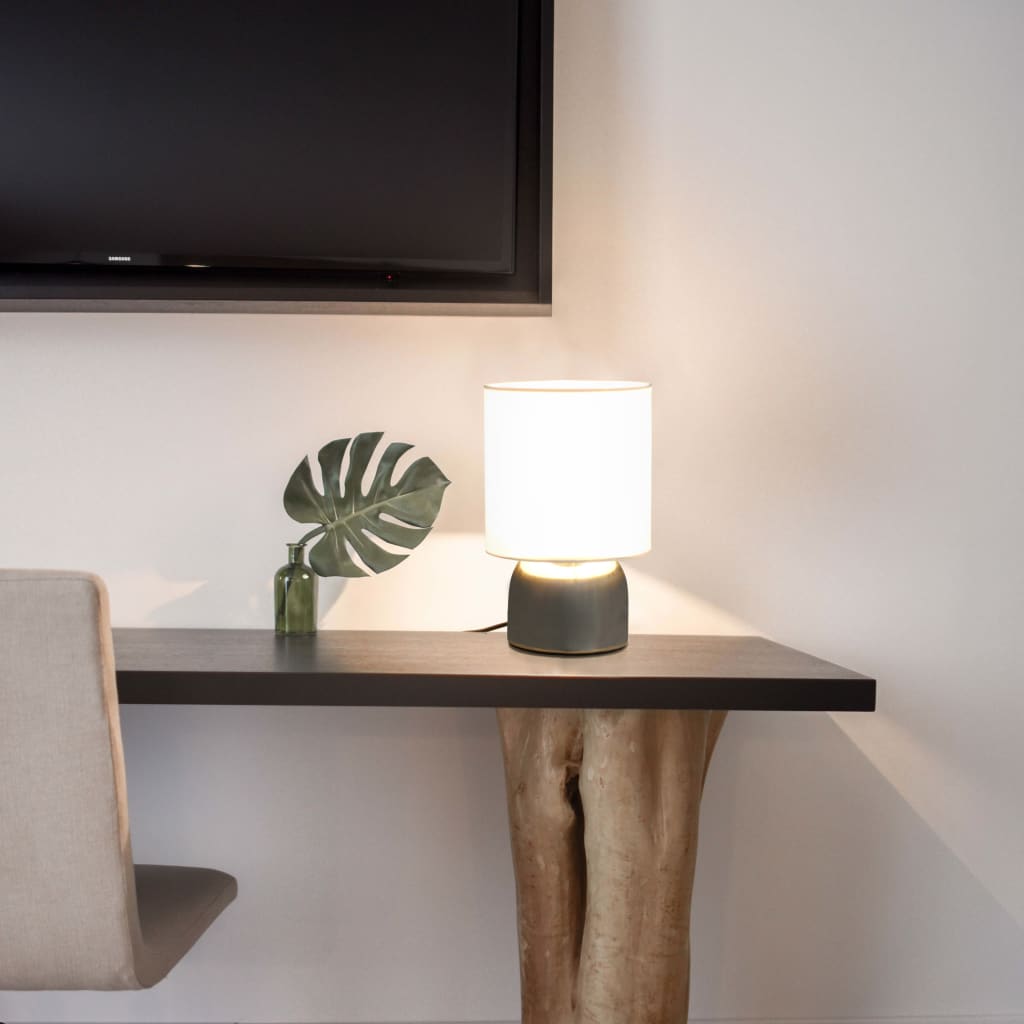 Bordlampe på sidebord ved TV-væg i moderne hjem, hvid skærm og keramik-base med plante som dekoration