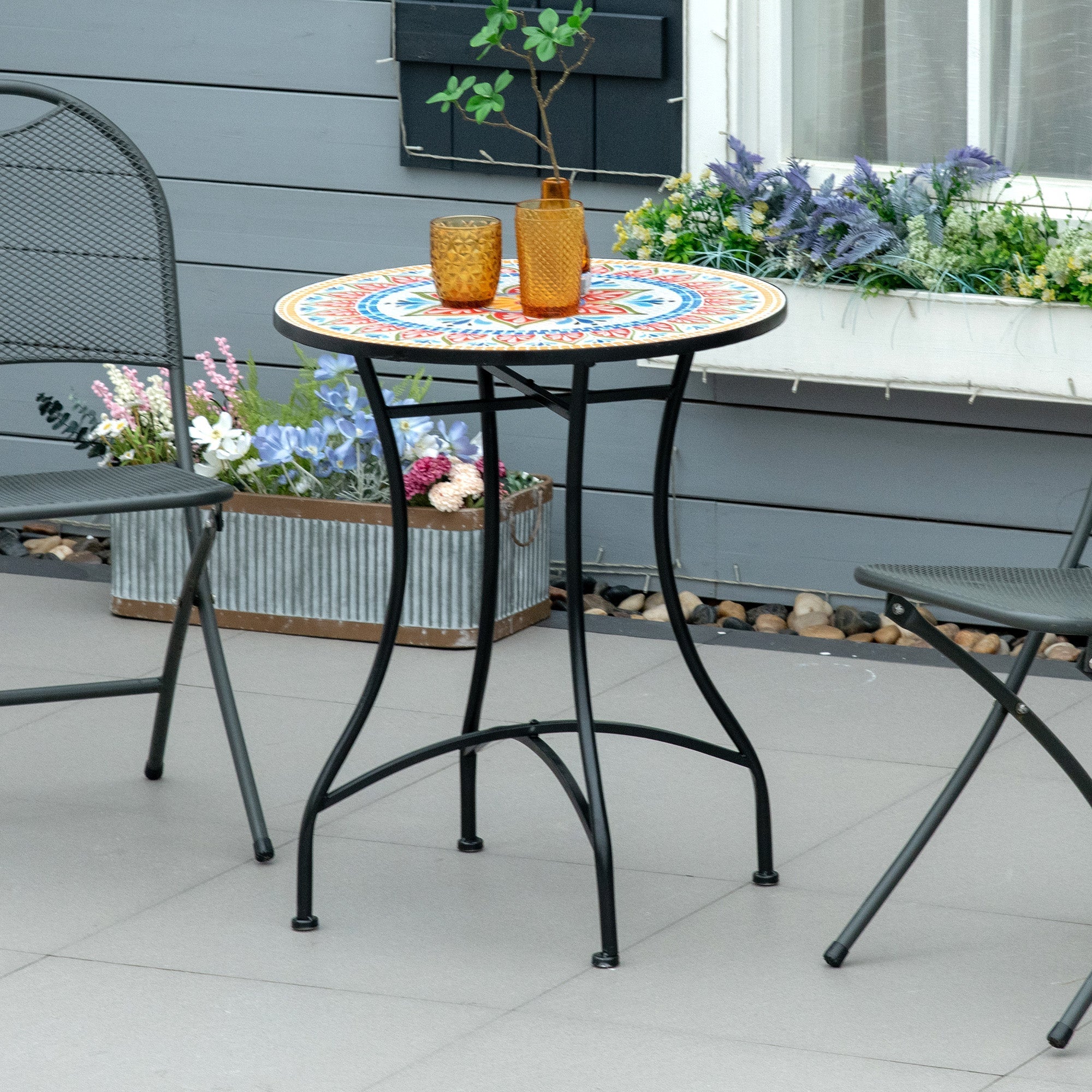 Rundt balkonbord 60 cm med farverig keramisk mosaik-bordplade på terrasse med plantekrukke og havestole i moderne udendørs miljø