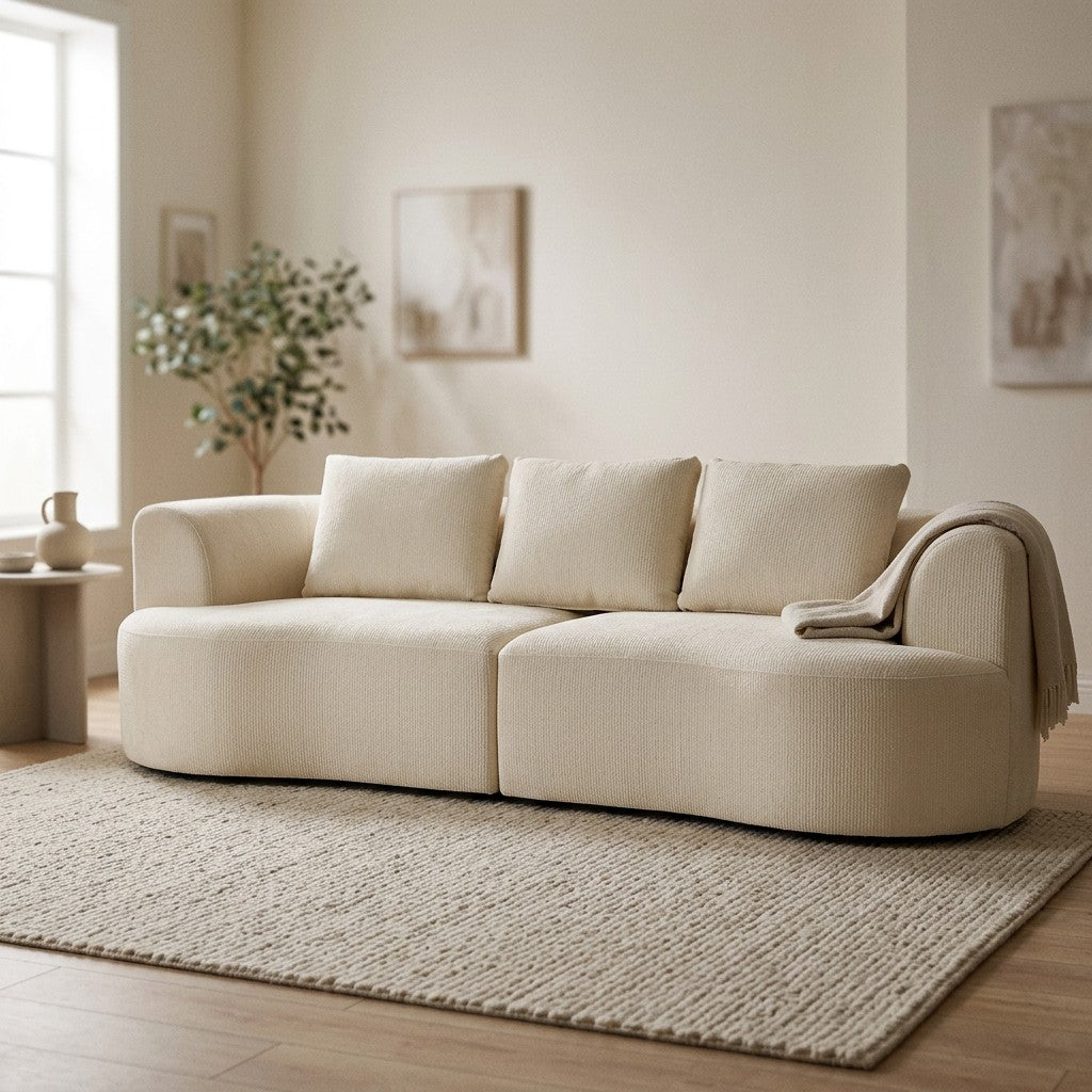 Tre-personers chenillesofa i creme med god plads omkring i en lys stue