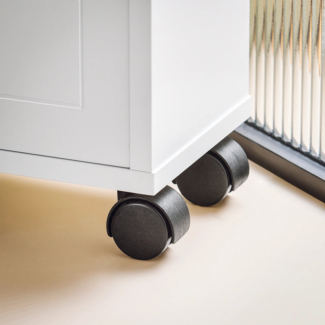 Hvidt badeværelseskabinet på hjul, ideelt til opbevaring af toiletpapir og diverse