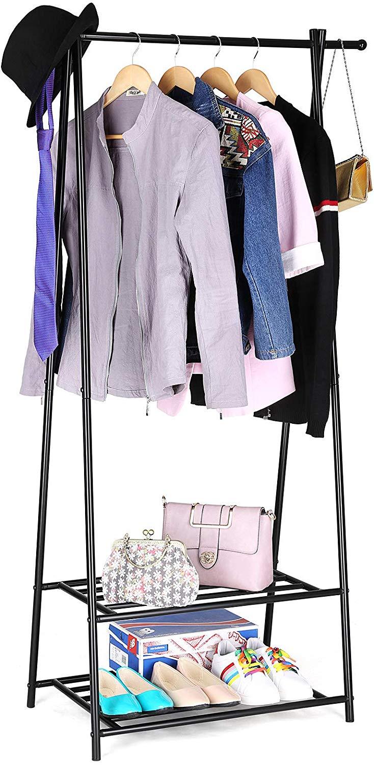 Tøjstativ med 2 hylder i sort, fyldt med sko og hængende tøj, placeret ved siden af vinduet